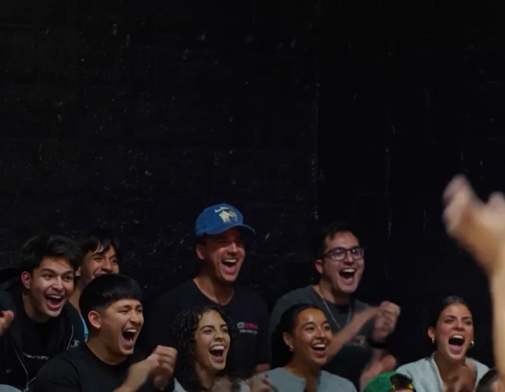 A Courtside crowd cheering from the sideline
